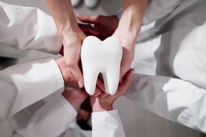 Hands holding a tooth